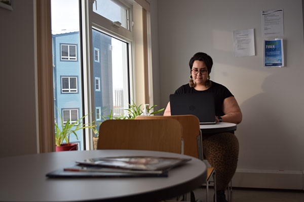 Une femme inuite travaillant sur un ordinateur portatif dans un bureau ensoleillé.